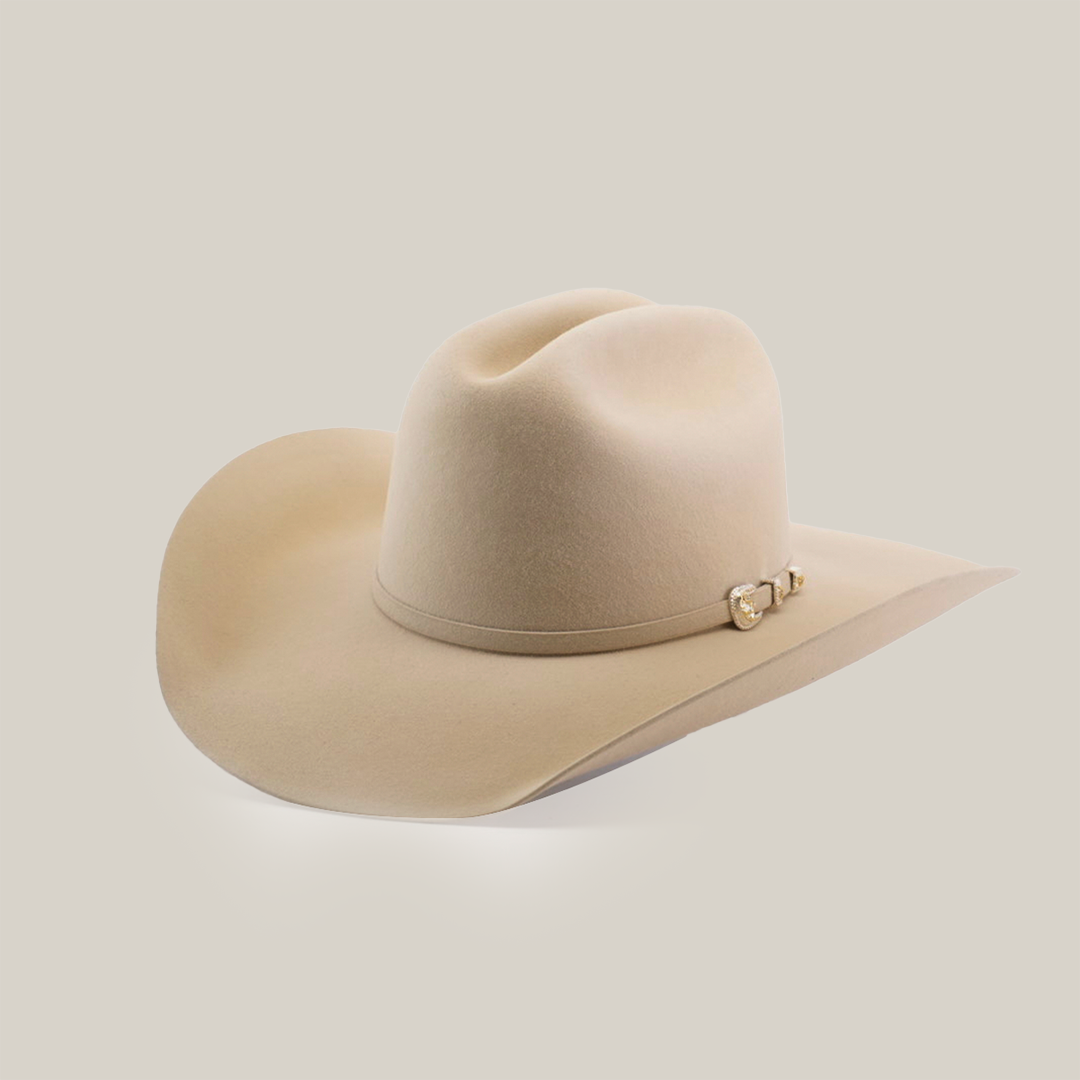 A beige cowboy hat with a wide brim and a decorative band featuring small metal buckles on a light background.