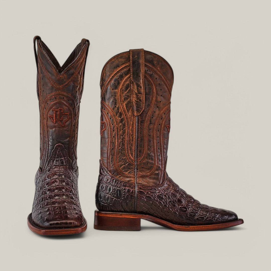 The Alligatoar Horn Back Print Brown boots display intricate embossed designs with a logo, resembling alligator horn back skin. Their square toe and shiny finish can be seen from both front and side views.