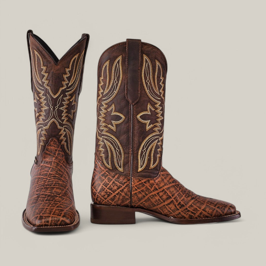The Mamut Grimm Brown - Square Toe cowboy boots feature premium leather, intricate stitching, and a textured pattern. With a pointed toe and medium-height heel, they are elegantly showcased on a plain background.