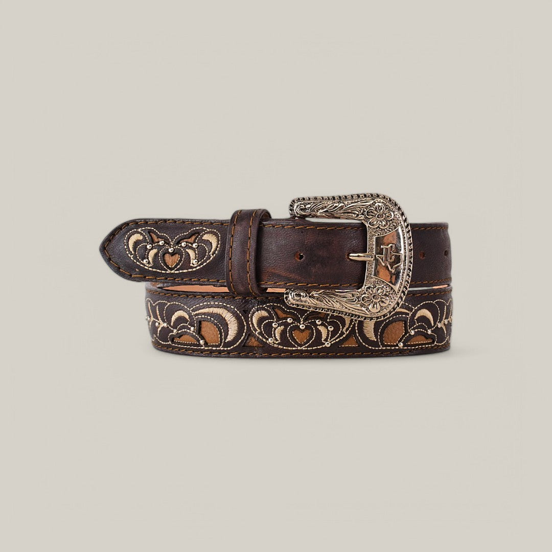 The Oklahoma Brown Belt - Texas Buckle is a dark brown leather accessory with an ornate silver buckle, embossed heart patterns, and decorative stitching. Ideal for enhancing womens wardrobes with its elegant design against a plain, neutral background.