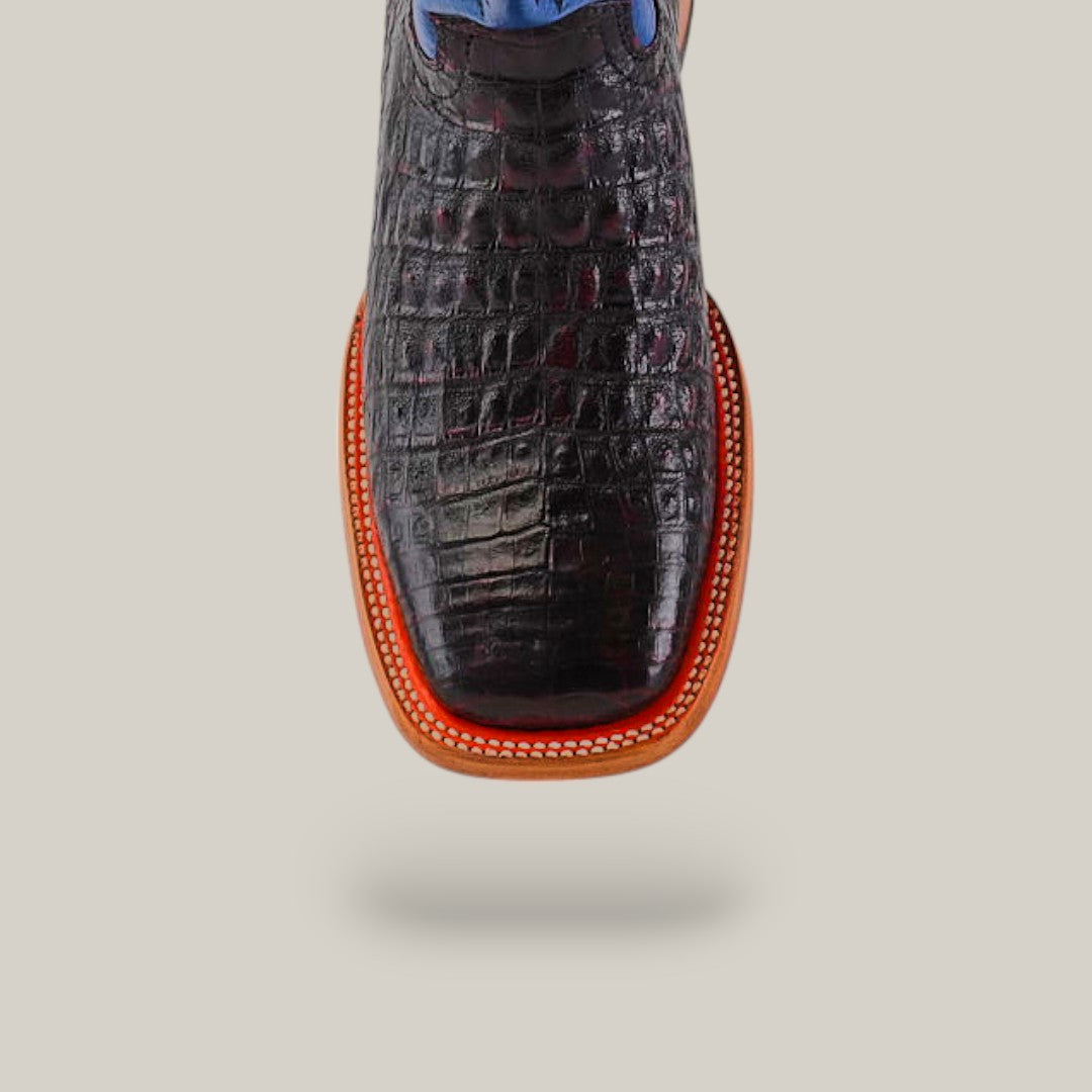 A handcrafted Exotic Caiman Belly shoe in Black Cherry with a square toe, blue laces, and red-trimmed sole is shown front-facing on a plain background. Crafted from exotic leather, it appears to float gracefully with a shadow underneath.