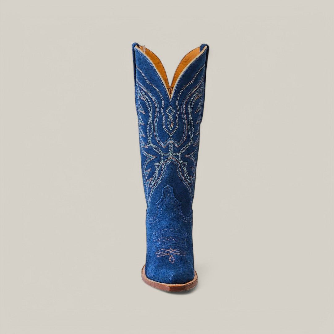 The Miranda Suede Blue Jeans Leather Sole boot showcases a vibrant blue single snip toe design with intricate white embroidery, a sturdy brown leather sole, and stands upright against a plain light grey background.
