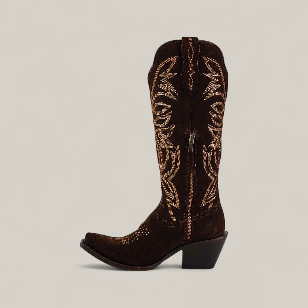 The Kellie Suede Brownie Tall Shaft Boot features dark brown suede, tan stitching, a snip toe, medium-high angled heel, leather sole, and side zipper. Shown against a plain light beige background.