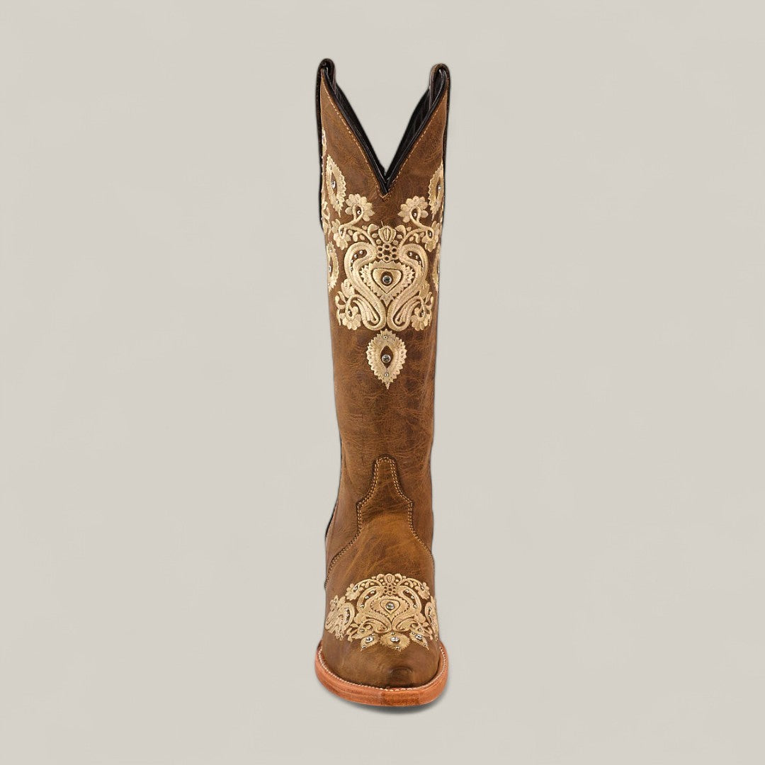 The Roxanne Crystals Tabaco boot features a tall brown leather shaft and snip toe, accented with intricate cream embroidery, displayed upright against a plain light background.