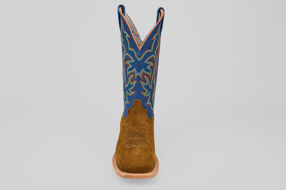 The Gold Suede - Square Toe boot features a brown suede foot and a tall blue shaft with multicolored decorative stitching, displayed upright and facing forward against a plain light background.