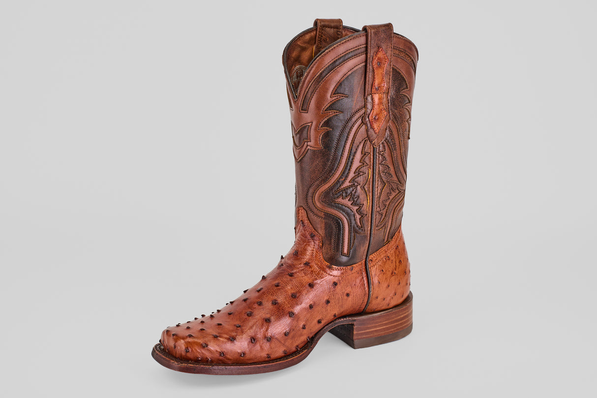 The Exotic Ostrich - Brandy - Rodeo Toe boot, made from genuine ostrich leather, showcases decorative stitching on its tall shaft and a textured quill pattern on the foot, set against a simple light background.