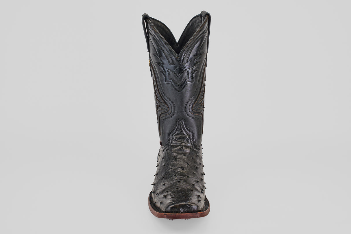 The Exotic Ostrich - Black - Rodeo Toe is a single black cowboy boot featuring a textured, ostrich-style surface and a pointed rodeo toe, shown from the front against a plain white background.
