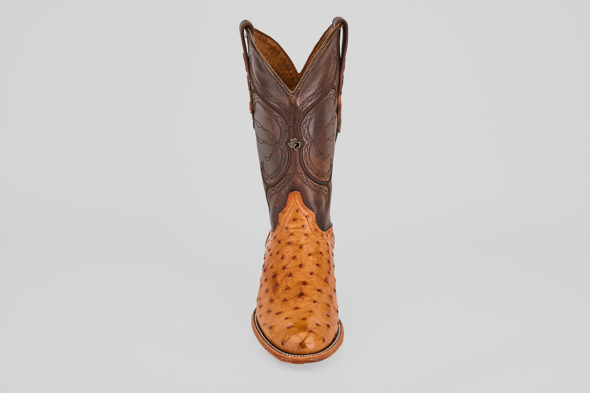 The Austin - Brandy - Roper Toe is a men's cowboy boot featuring a brown leather upper and light tan textured ostrich leather lower, shown upright on a plain white background. Ideal for fans of classic ostrich leather boots.