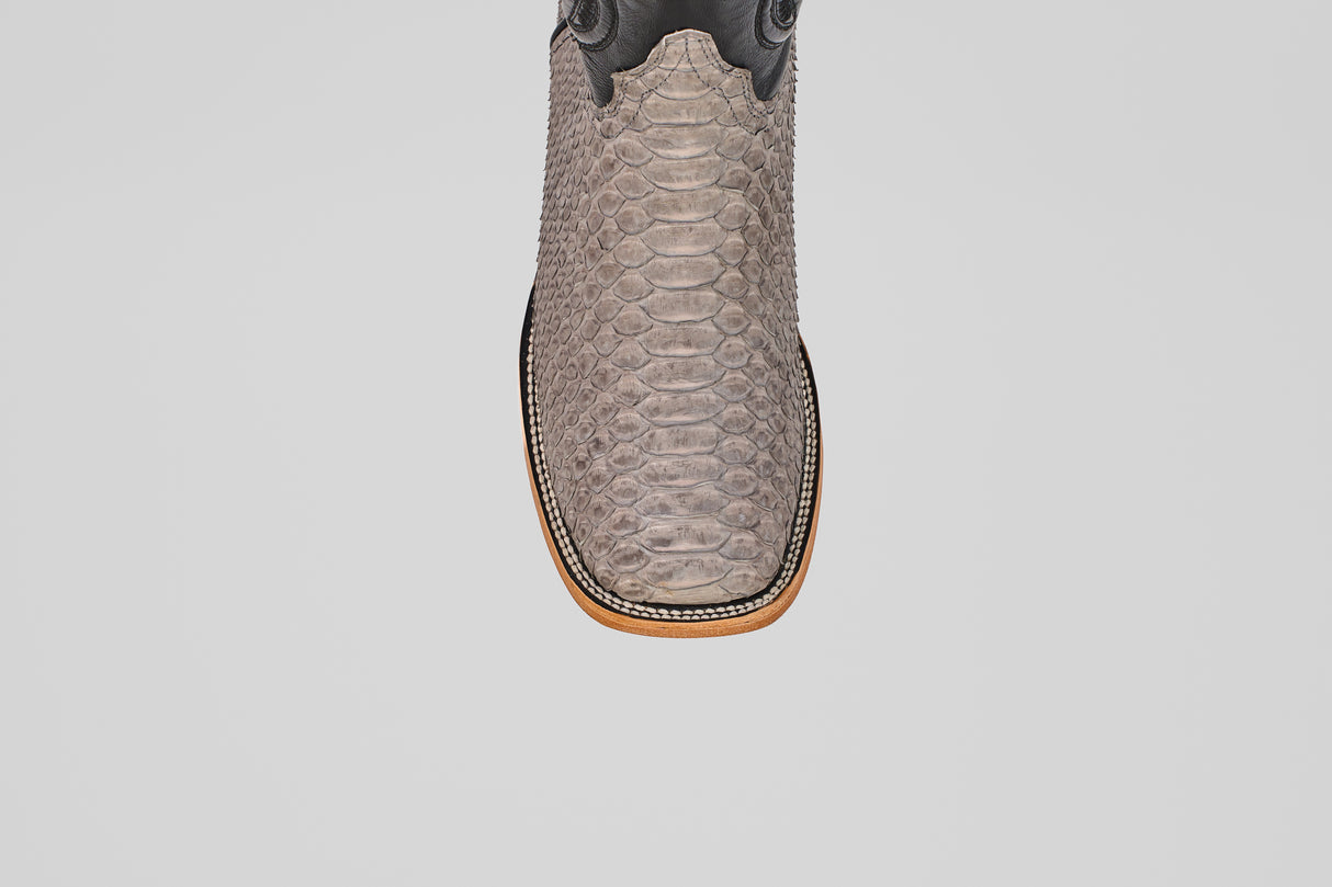 A close-up top view of the Tanner - Matte Gray - Square Toe cowboy boot in Python Gris Nobuck leather, showcasing its textured, snake-like pattern and distinctive square toe against a plain white background.