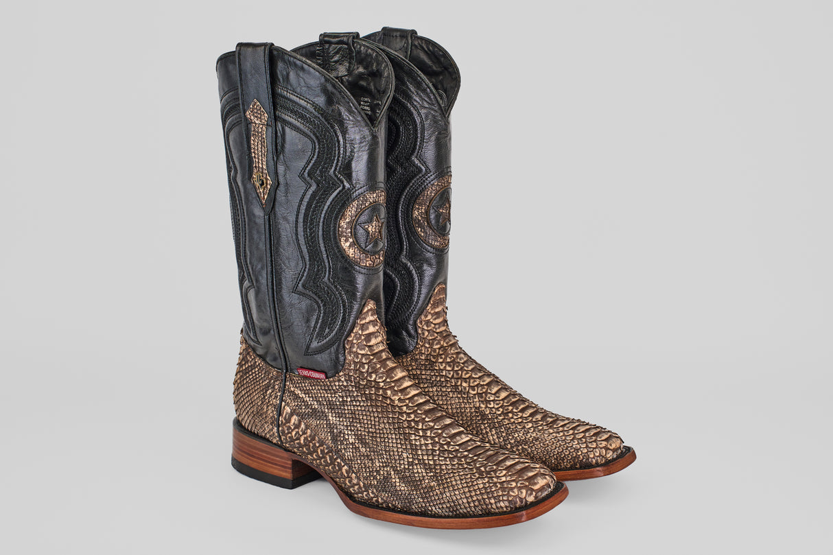 The Tanner - Rustic Bone - Square Toe cowboy boots feature dark black leather tops, brown snakeskin-patterned lowers, decorative stitching, and wooden heels—all displayed on a light gray background.