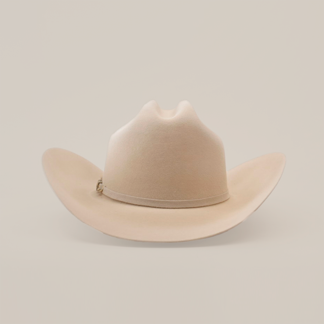 The 10X Jerarca Belly is a beige cowboy hat with a curved brim and distinct top crease, made from fur felt. Featuring a subtle hatband, this piece of Western headwear is displayed against a plain white background.
