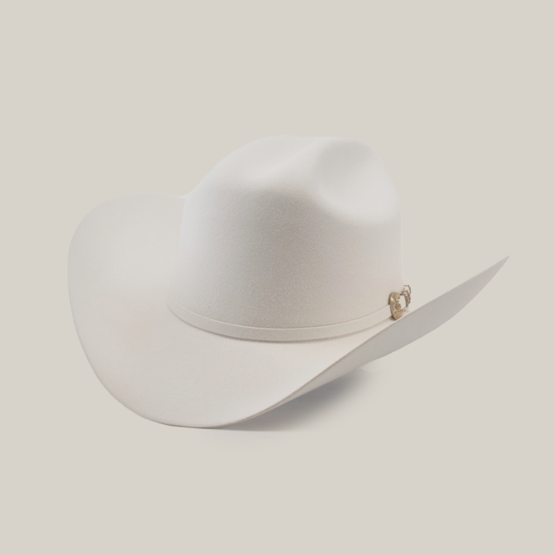 The 500X Superior White is a luxury Western cowboy hat with a wide brim and curved crown, made from top-quality belly beaver fur. It features a subtle band with a small gold emblem on a plain, light background.