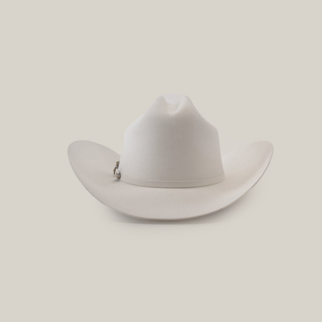 The 1000X Imperial White hat, featuring a pin on the side, is elegantly showcased against a plain light gray background, exuding timeless charm.