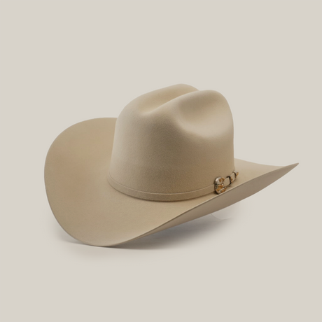 A beige cowboy hat with a wide brim and a decorative band, set against a light, plain background.