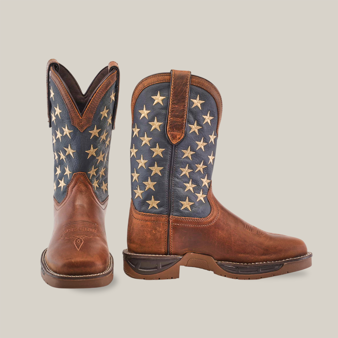 Against a white background, two premium cowhide leather cowboy boots are displayed. The left boot has a zigzag top design, and the right features white stars on a blue backdrop. Rugged construction ensures these Navy Brown US Flag Waterproof - Composite Toe boots offer both style and durability.