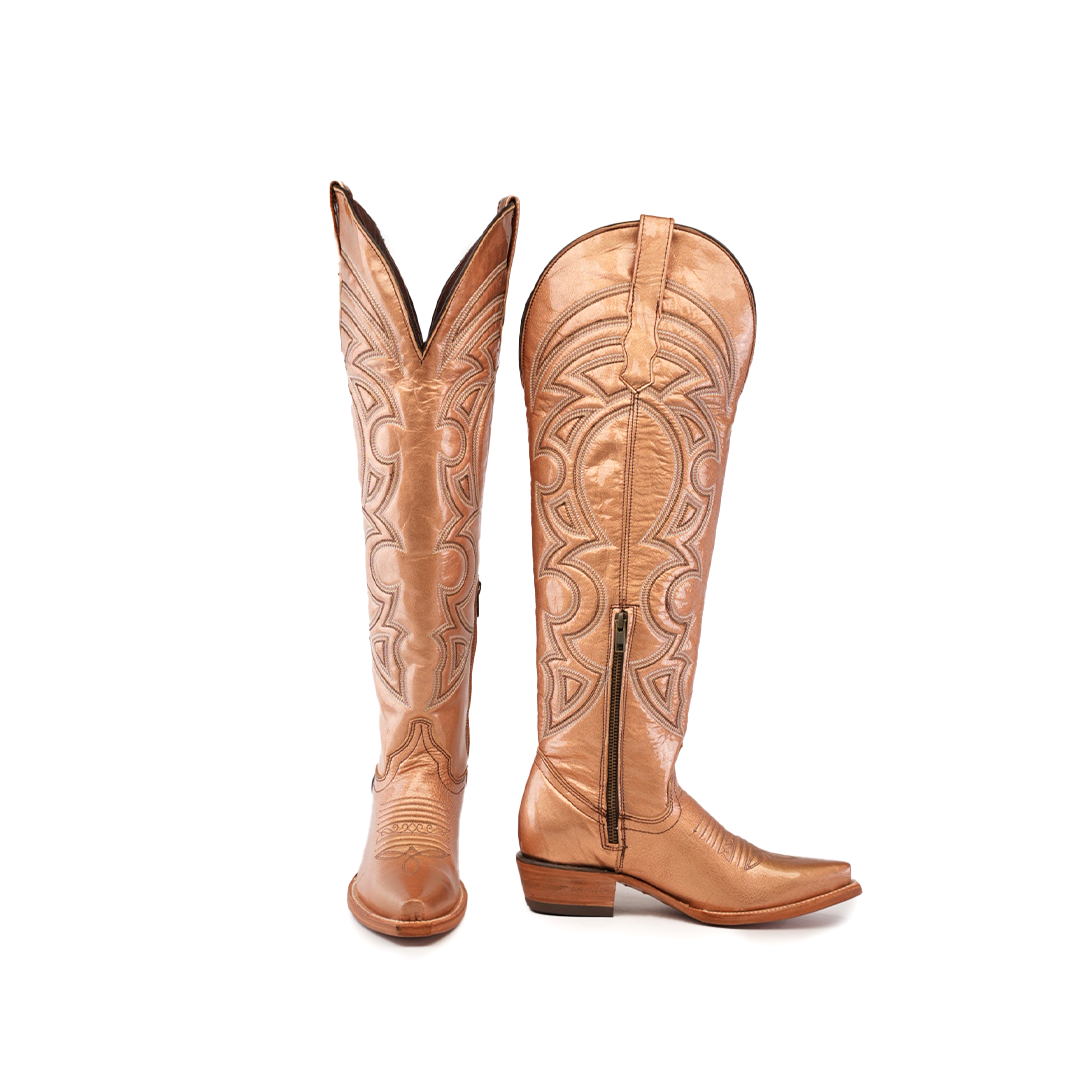 A pair of Taylor Rose Gold cowboy boots, tall and light brown leather with intricate embossed designs, featuring a snip toe and low heel. The left boot stands upright; the right is angled to show its side.