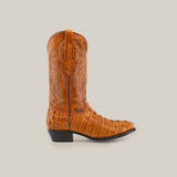 The Crocodile Tail Print Buttercup - Round Toe is a brown leather cowboy boot with intricate embroidery on the shaft and crocodile tail texture on the foot, crafted from premium cowhide leather, featuring a genuine leather sole and black heel against a white background.