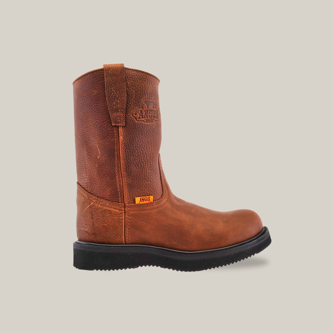 The Brandy Roper - Tractor Sole - Composite Toe is a premium brown leather work boot crafted from cowhide, featuring pull tabs and a durable black rubber sole. It includes an embossed logo near the top and a small fabric tag on the side, highlighted against a white background for rugged appeal.