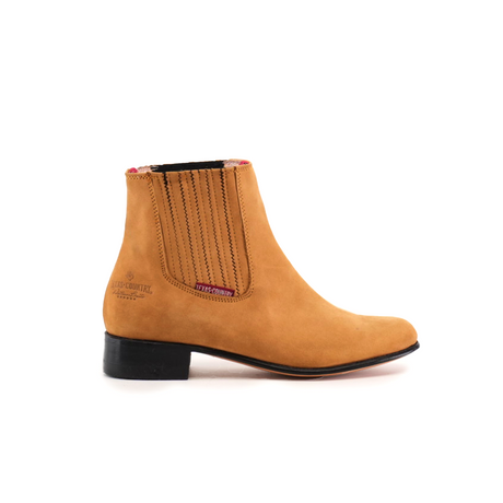 The Prime Suede Honey Round Toe ankle boot in tan leather boasts an elastic side panel, low black heel, stitched accents, a round toe, the brand embossed near the heel, and a plaid lining. Ideal for enhancing a Cowboy Scene. Presented on a white background.