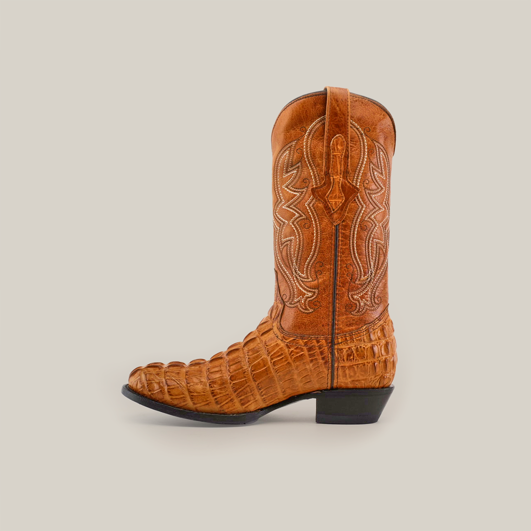 The Crocodile Tail Print Buttercup boot features a round toe and elegant light brown cowhide leather with detailed stitching and a textured pattern, displayed against a white background.