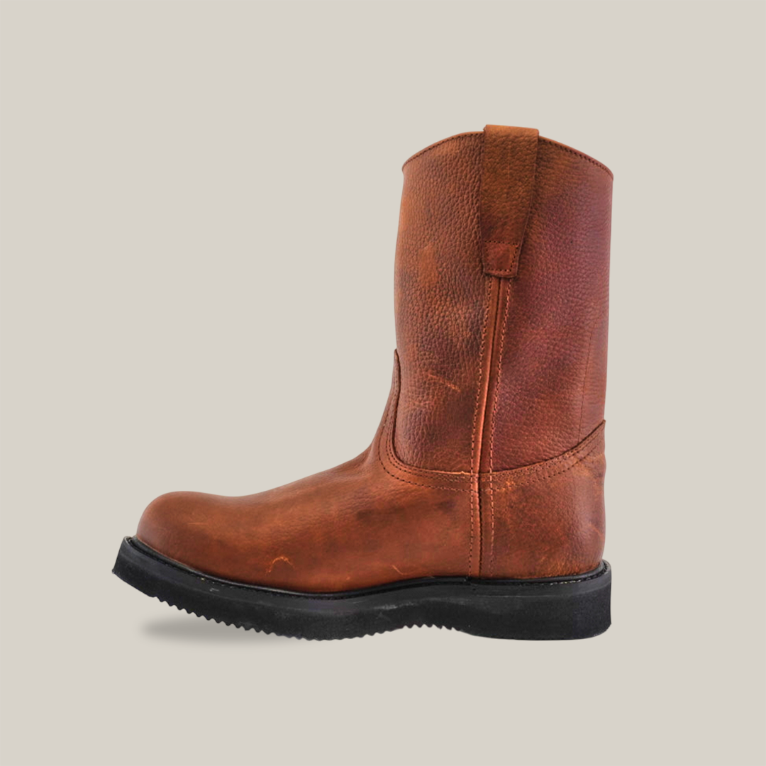 The Brandy Roper - Tractor Sole - Composite Toe boot, crafted from premium cowhide leather, features a rugged sole. Set against a white backdrop, its pull tabs and round toe demonstrate handcrafted excellence and sturdy design.