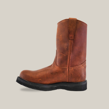 The Brandy Roper - Tractor Sole - Composite Toe boot, crafted from premium cowhide leather, features a rugged sole. Set against a white backdrop, its pull tabs and round toe demonstrate handcrafted excellence and sturdy design.