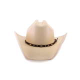 The 1000X Country Straw Hat, a beige masterpiece, features a wide brim and a decorative black band adorned with small silver conchos around the base of the crown, set against a white background. Crafted from high-quality materials, this cowboy hat stands out for its impeccable design and style.