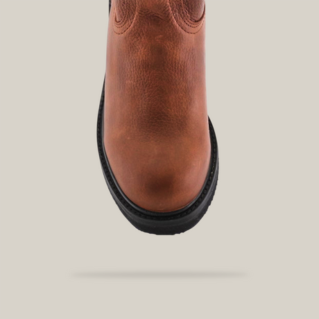 The image features a close-up of the Brandy Roper - Tractor Sole - Composite Toe boot on a white background, highlighting its brown leather texture, stitching details, and black rubber tractor sole.