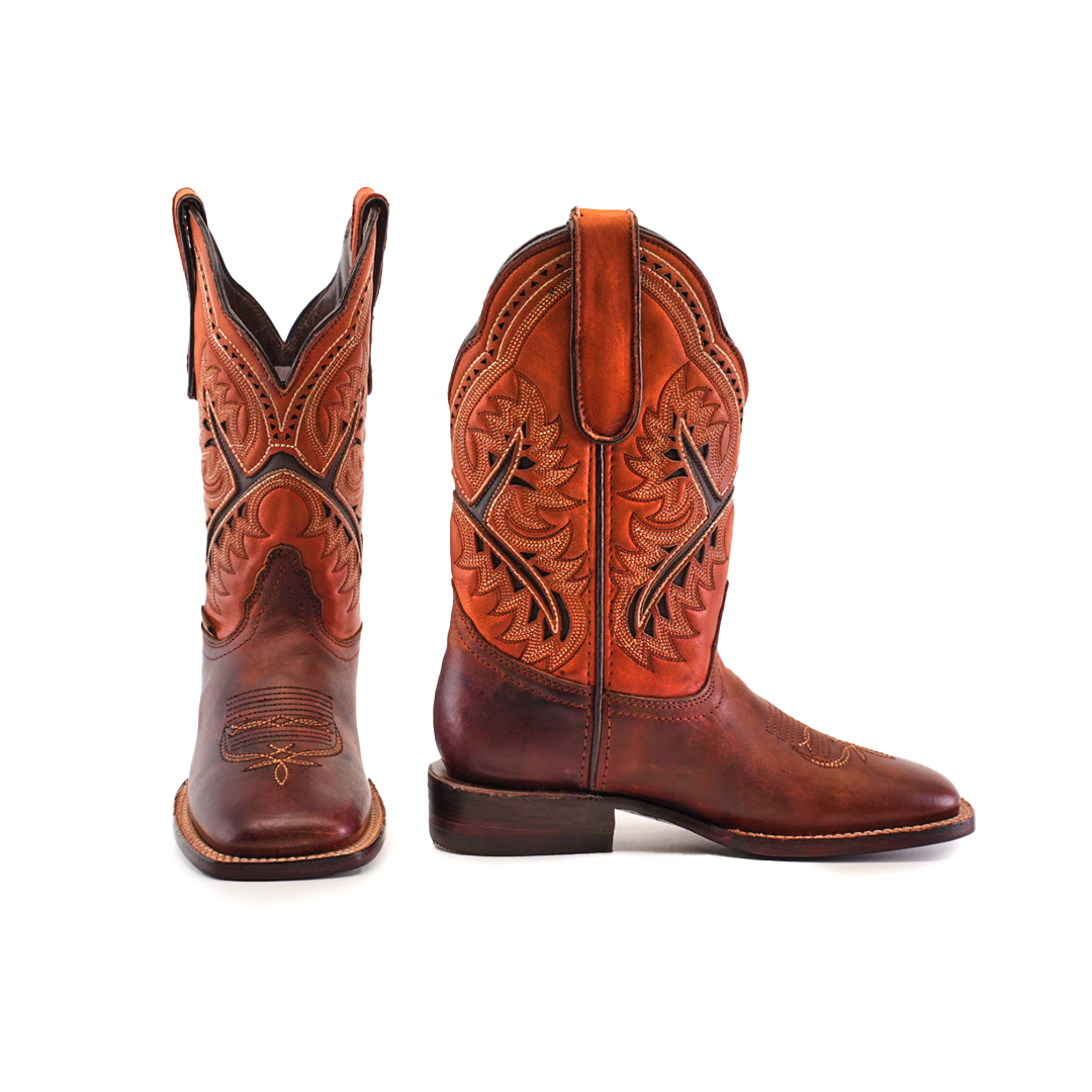 Two Azkar Moka Square Toe cowboy boots made from premium materials feature intricate leather stitching. One boot faces forward, highlighting the square toe design, while the other shows a side profile. Decorative patterns and a pull strap complete their look against a plain white backdrop.