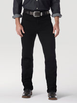 Someone wearing sleek Wrangler Cowboy Cut Slim Fit Jeans, a dark button-up shirt with rolled sleeves, paired with a decorative belt featuring a silver buckle, and stylish dark leather shoes, stands against a plain light-colored background that highlights the ensembles modern appeal.