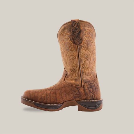 A Tan Brown Rough out cowboy boot showcases tan brown leather, detailed stitching, and a durable sole. From the side, the high shaft and curved toe highlight the premium cowhide leather against a white backdrop. This single handcrafted boot is waterproof with a composite toe for added safety.