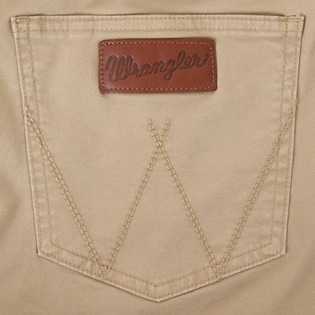 Close-up of a beige denim pocket with detailed stitching and a brown leather patch embossed with Wrangler, embodying the classic vibe of Mens Wrangler Retro Slim Fit Straight Leg Pant - 1088MWZFN.