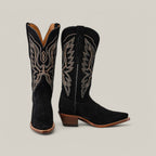 The Miranda Suede Black Leather Sole boots feature a snip toe design and intricate white stitching, set against a plain beige background, with medium brown heels.