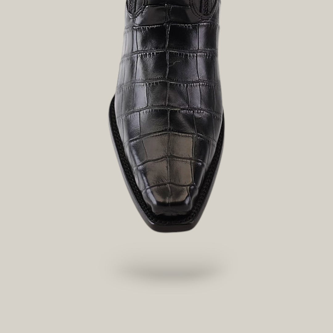 A close-up of the Alligator Belly Black - Narrow Square Toe - IMPERIO shoe showcases its crocodile texture, akin to Cuadra Boots, centered on a light gray background.