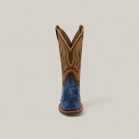 The Exotic Full Quilt Ostrich - Blue - Square Toe boot, featuring a blue textured lower and brown upper with yellow stitching, is displayed upright and forward against a plain light background.