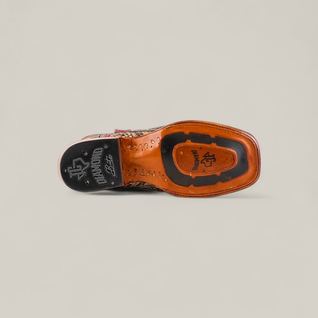 The image displays the underside of the Exotic Python - Natural - Square Toe boot, featuring visible tread, brand logos, and decorative sole stitching from the Platinum Collection, set against a plain light background.