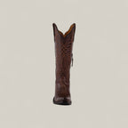 The Kellie Clayton Caramel Leather Sole boot features a tall shaft, snip toe, and decorative stitching, shown upright against a light beige background—perfect for stylish womens boot enthusiasts.