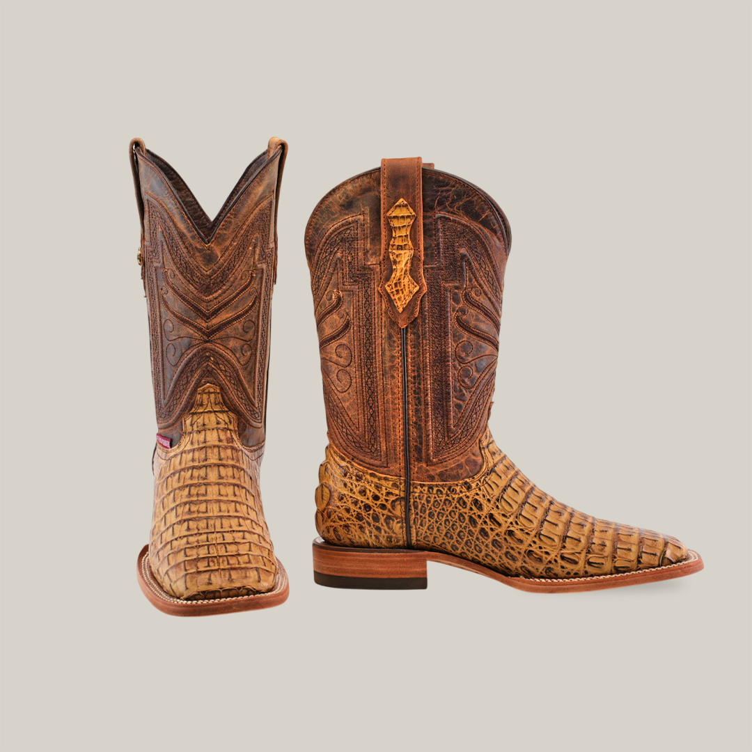 A pair of Exotic Caiman Horn Back - Biza Camel - Square Toe boots, featuring handcrafted intricate patterns. The right boot shows the side with brown leather and elaborate designs, while the left showcases the front with its unique Biza Camel patterns.