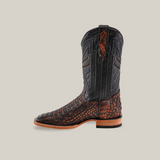 The Exotic Caiman Horn Back - Roma - Square Toe boot features a textured brown caiman skin lower with a black leather upper and intricate stitching. It has a tan sole, low heel, and is set against a light beige background for that Western wardrobe touch.