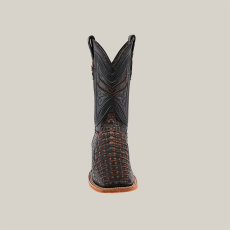 The Exotic Caiman Horn Back - Roma - Square Toe boot showcases a dark, intricate upper with brown textured patterns on the foot, featuring a natural-colored sole that enhances any Western wardrobe, elegantly set against a plain light background.