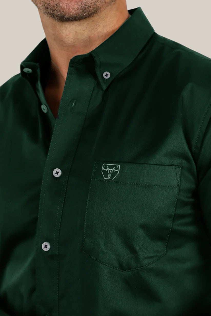 A person wears the Mens Modern Fit Stretch Dress Shirt in dark green, featuring a single pocket with an embroidered bull logo.