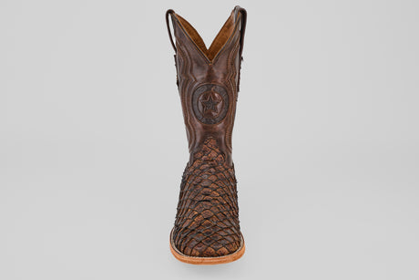 The Exotic Pirarucu Fish - Brown - Square Toe boot features a textured, woven lower and star emblem on the upper shaft, shown from the front on a white background—ideal for exotic leather boot enthusiasts.