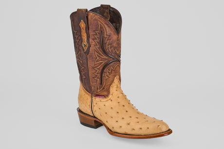 The Exotic Full Quilt Ostrich - Orix - Round Toe cowboy boot features a tall, brown stitched leather upper and a light tan, textured full quill ostrich leather foot, showcased against a plain white background.