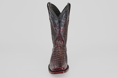 The Exotic Caiman Hornback - Blackcherry - Rodeo Toe boot, featuring a pointed toe, crocodile texture, and decorative stitching, stands upright against a plain light background.