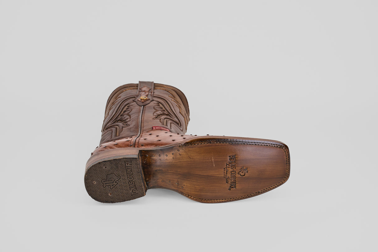 The Austin - Brown - Rodeo Toe boot, featuring rich Kango Tabaco leather and decorative stitching, is shown on its side with the branded sole and engraved logo visible—an ideal choice for rodeo enthusiasts.