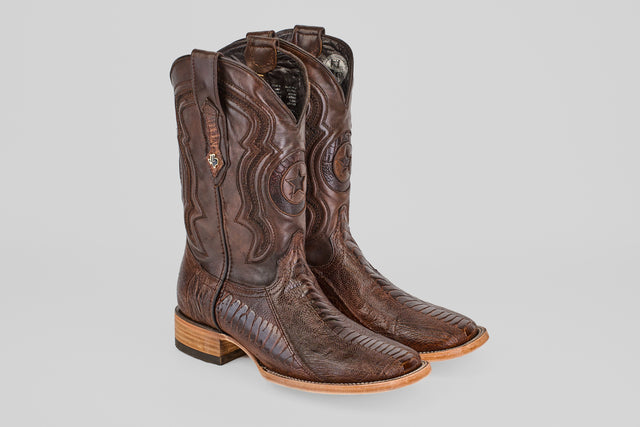 The Austin Leg - Brown - Square Toe boots feature decorative stitching, patterned details, wooden heels, pull straps, and a classic square toe, shown against a plain gray background.
