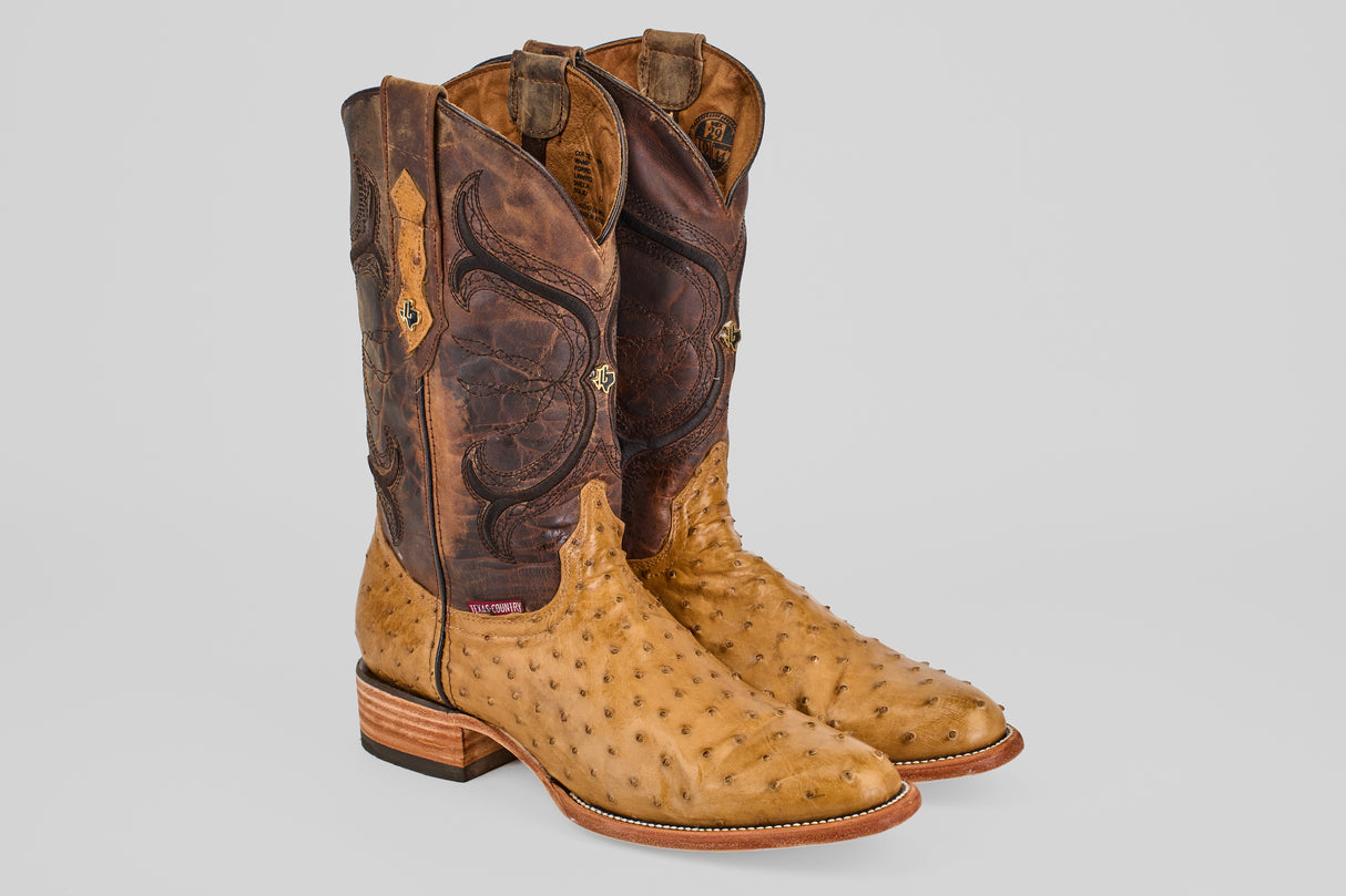 The Austin - Antique - Roper Toe boots feature tan ostrich leather on the foot and light brown, intricately stitched shafts, shown standing upright against a plain gray background.