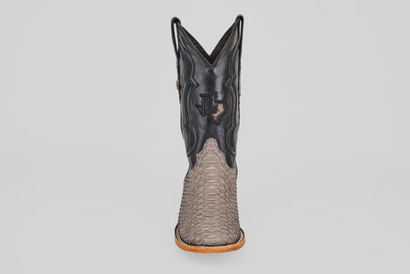 The Tanner - Matte Gray - Square Toe boot features a tan Python Gris Nobuck snakeskin-textured lower, a black leather upper with a stitched Texas emblem, and is shown from the front against a plain light background.