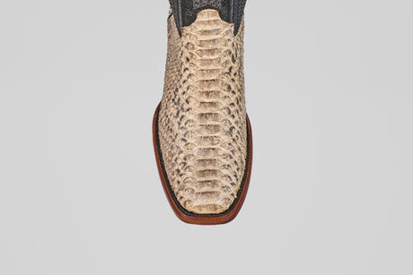 A close-up, top-down view of the Tanner - Natural - Narrow Square Toe boot displays its light python-textured snakeskin and dark upper, highlighting distinct Western style against a plain white background.