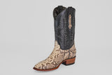 The Tanner - Natural - Roper Toe cowboy boot features a natural python-patterned lower half, black leather upper with decorative stitching, and a wooden heel, shown against a plain light gray background.